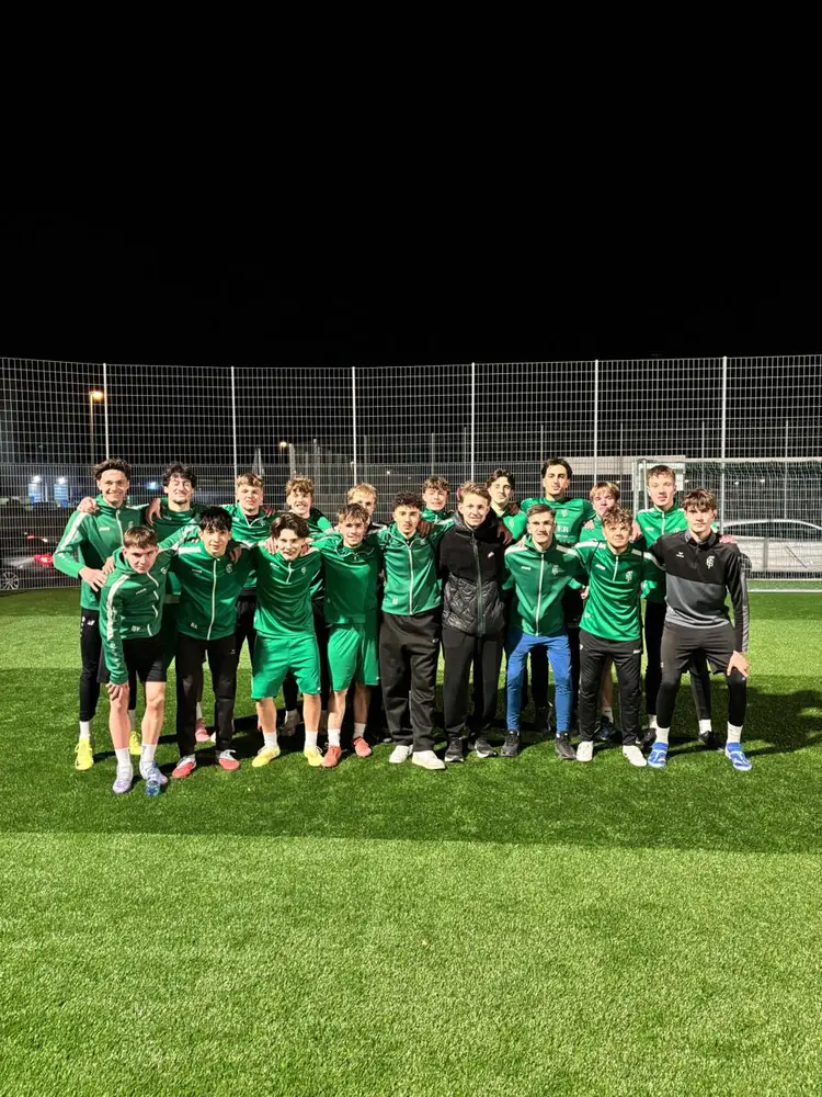 Nachwuchsmannschaft in grünen Jacken unter Flutlicht