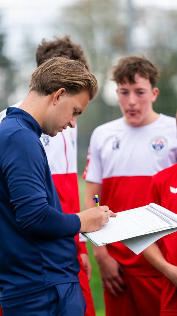 Coach notiert Ergebnisse gemeinsam mit einem Spieler