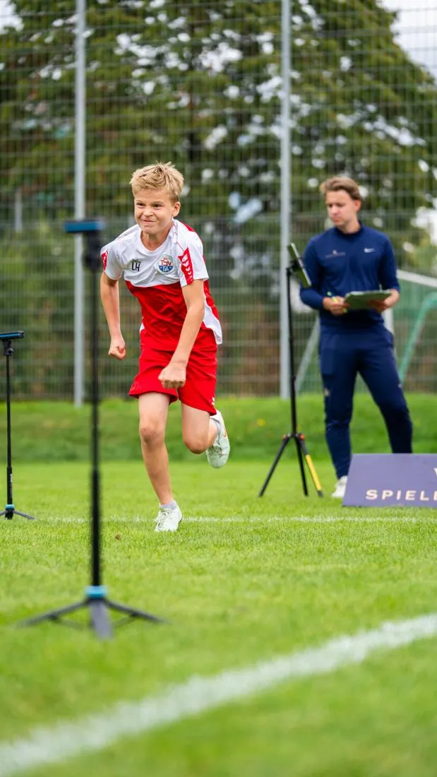 Spieler startet zum Sprint, Coach beobachtet