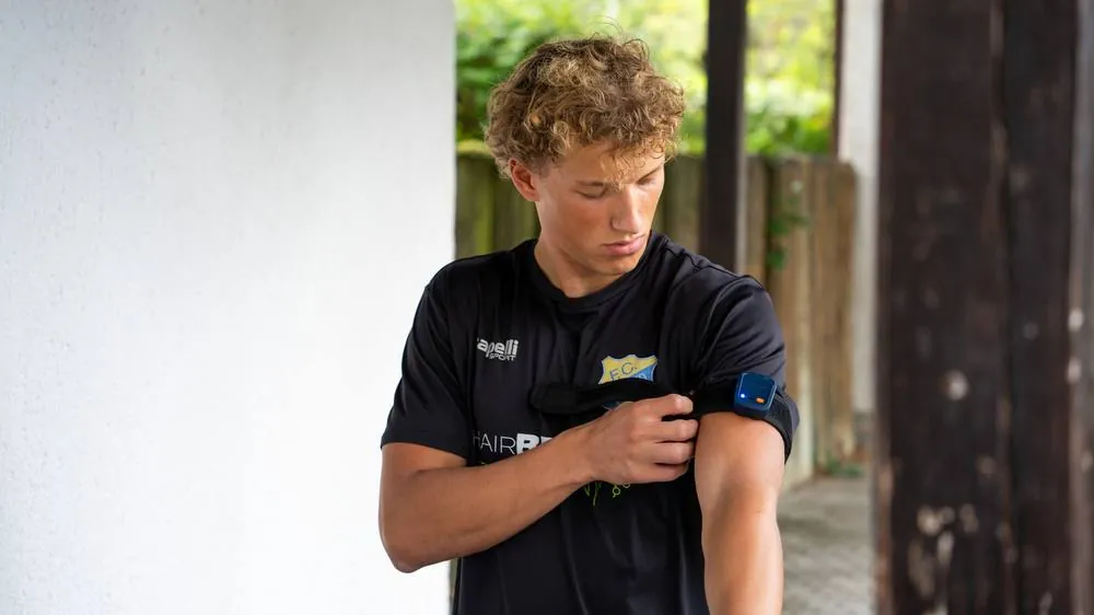 Athlet legt Messtechnik am Oberarm an