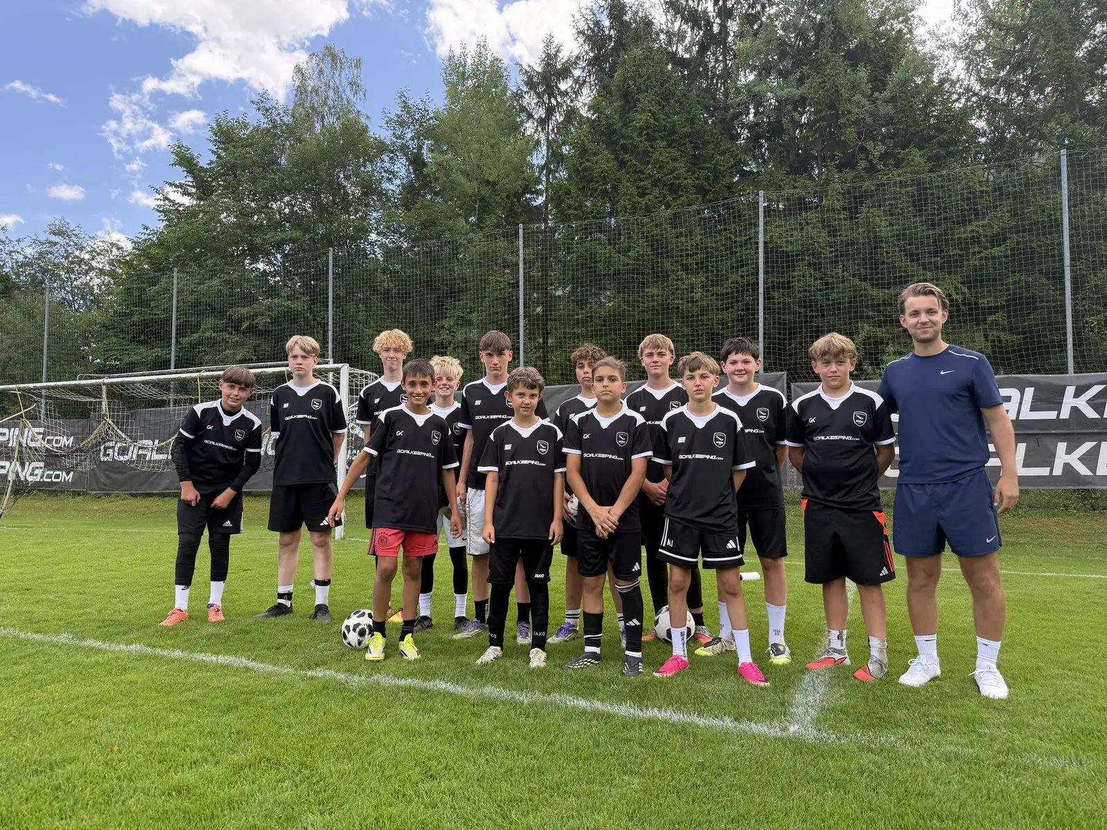 Camp-Mannschaft mit Spielerwerk-Coach auf dem Trainingsplatz