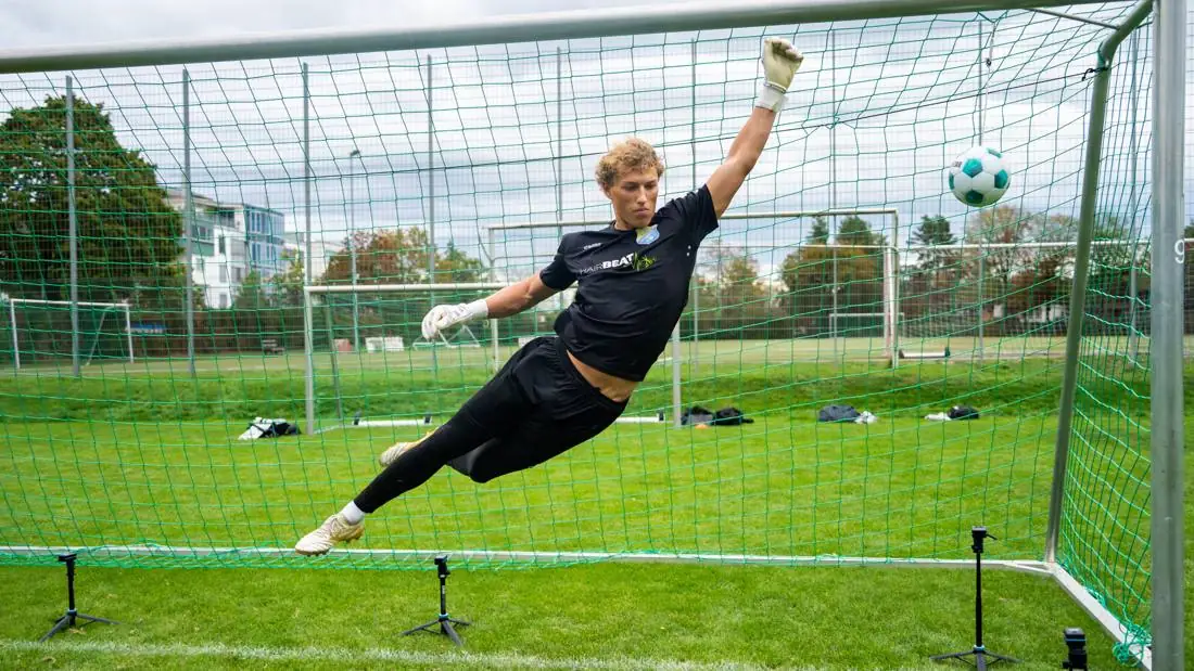 Torhüter streckt sich im Sprung nach dem Ball
